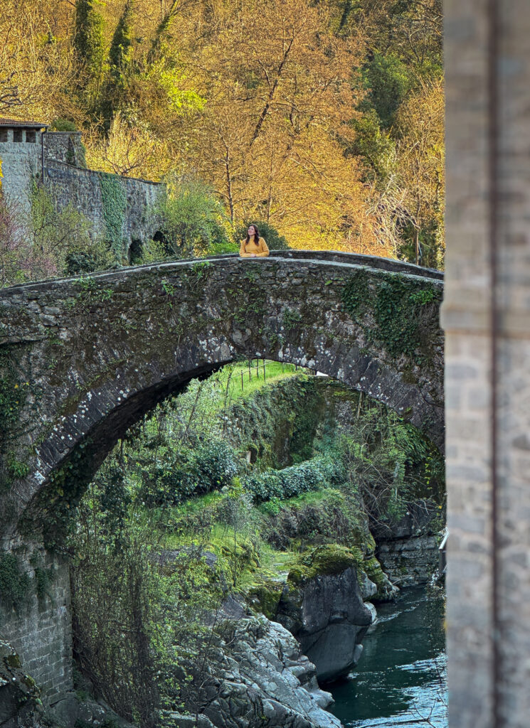 persona che sorride su un ponte medioevale a bagnone in Lunigiana